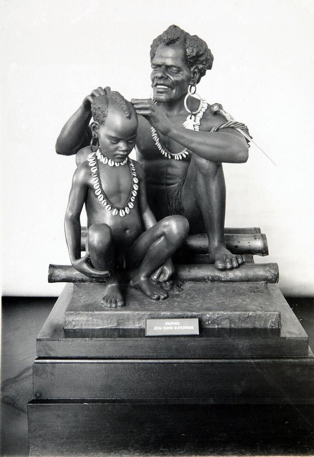 Beeldengroep van een Papua man en kind in het museum van het Koloniaal Instituut