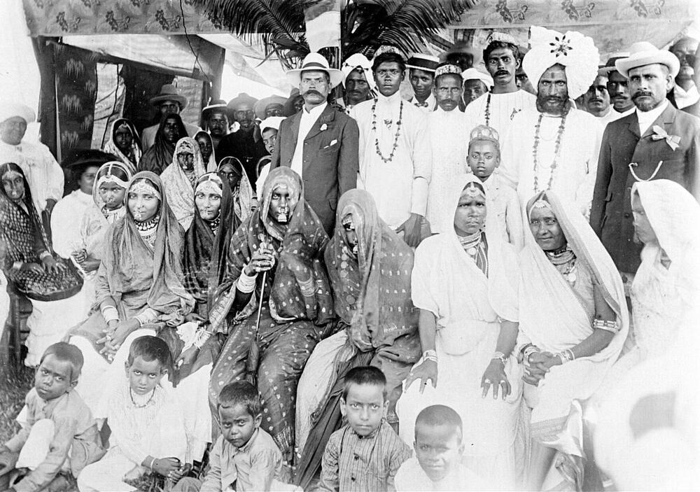 Groepsportret van Hindoestanen met Brits-Indische achtergrond tijdens een feest in Suriname