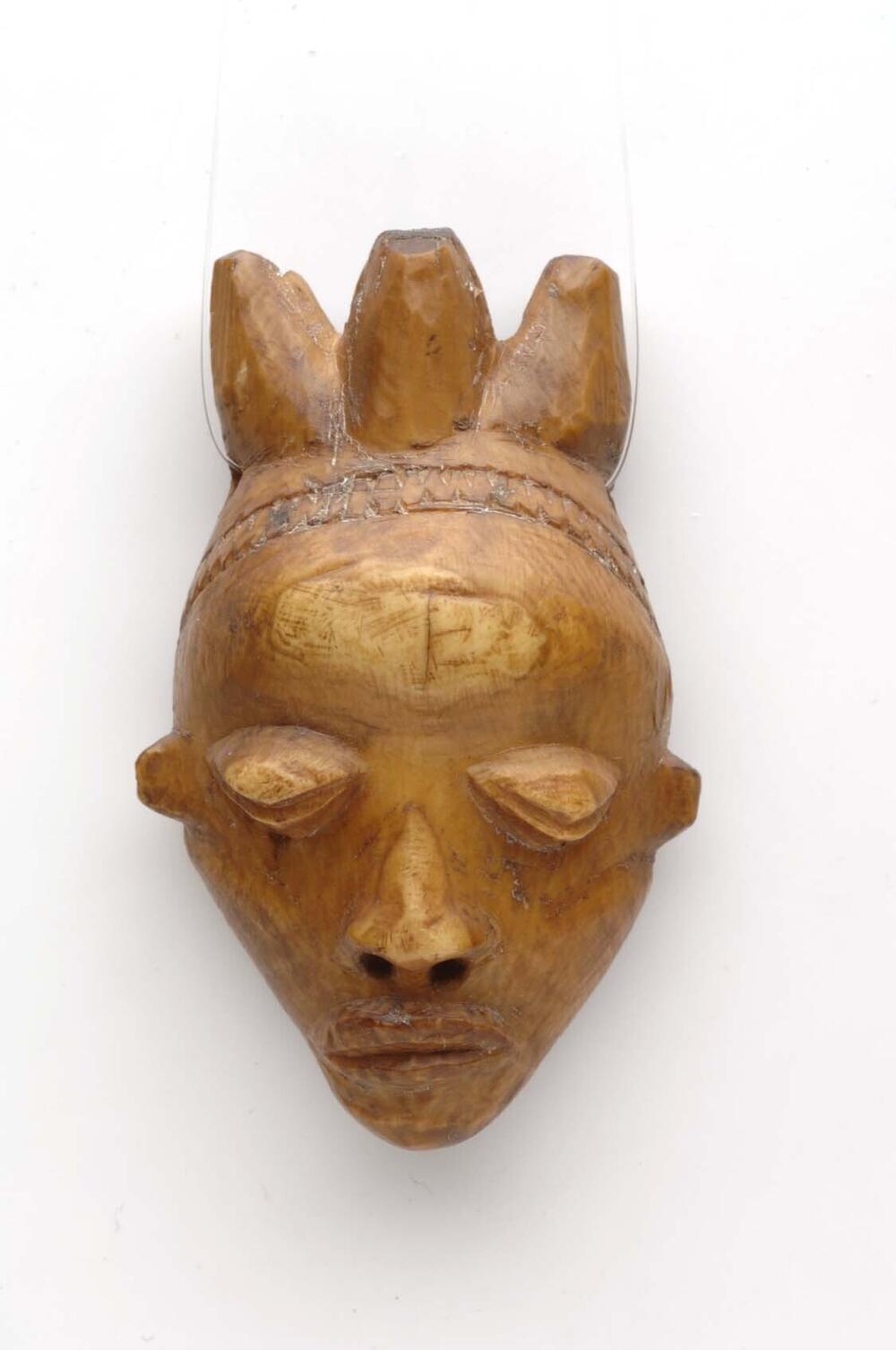 Ivoren hanger in de vorm van een miniatuurmasker