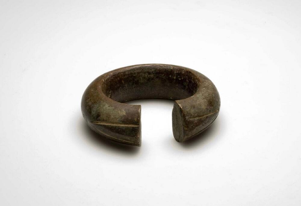 Bronzen armband aan de uiteinden gedecoreerd met twee lijnen die elkaar in een punt raken