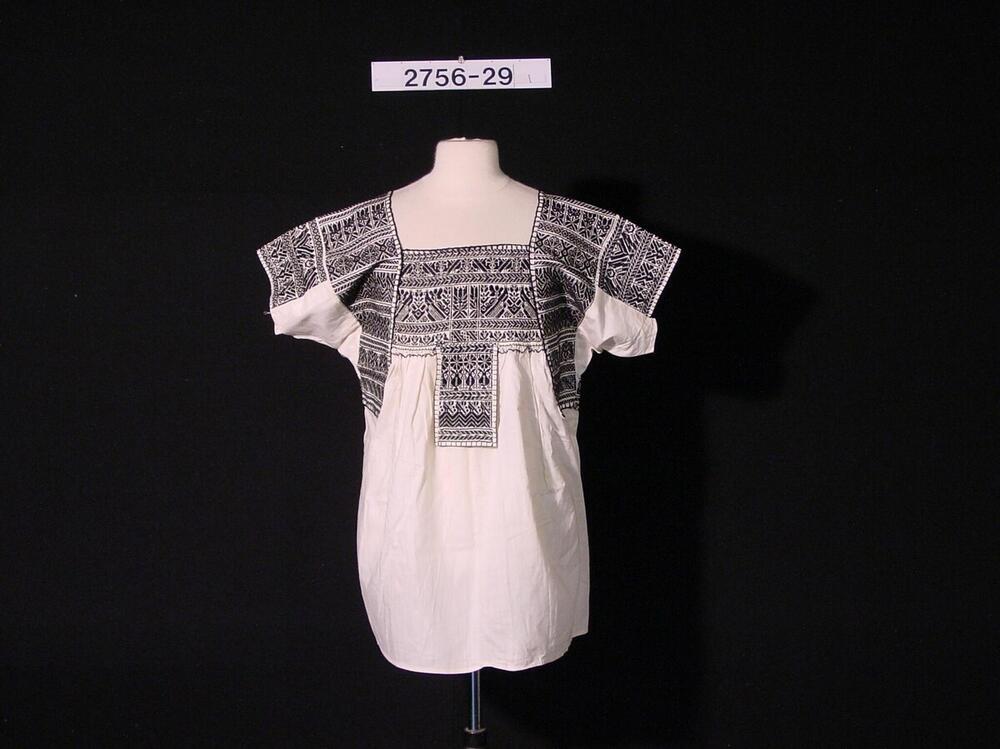 Witte katoenen vrouwenblouse met zwarte motieven op borst en schouders