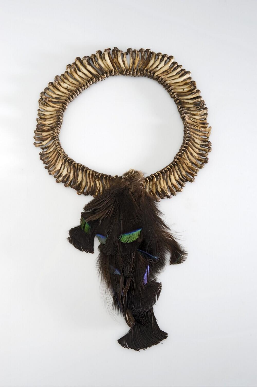Head ornament made of cuscus bones with feathers, worn by man