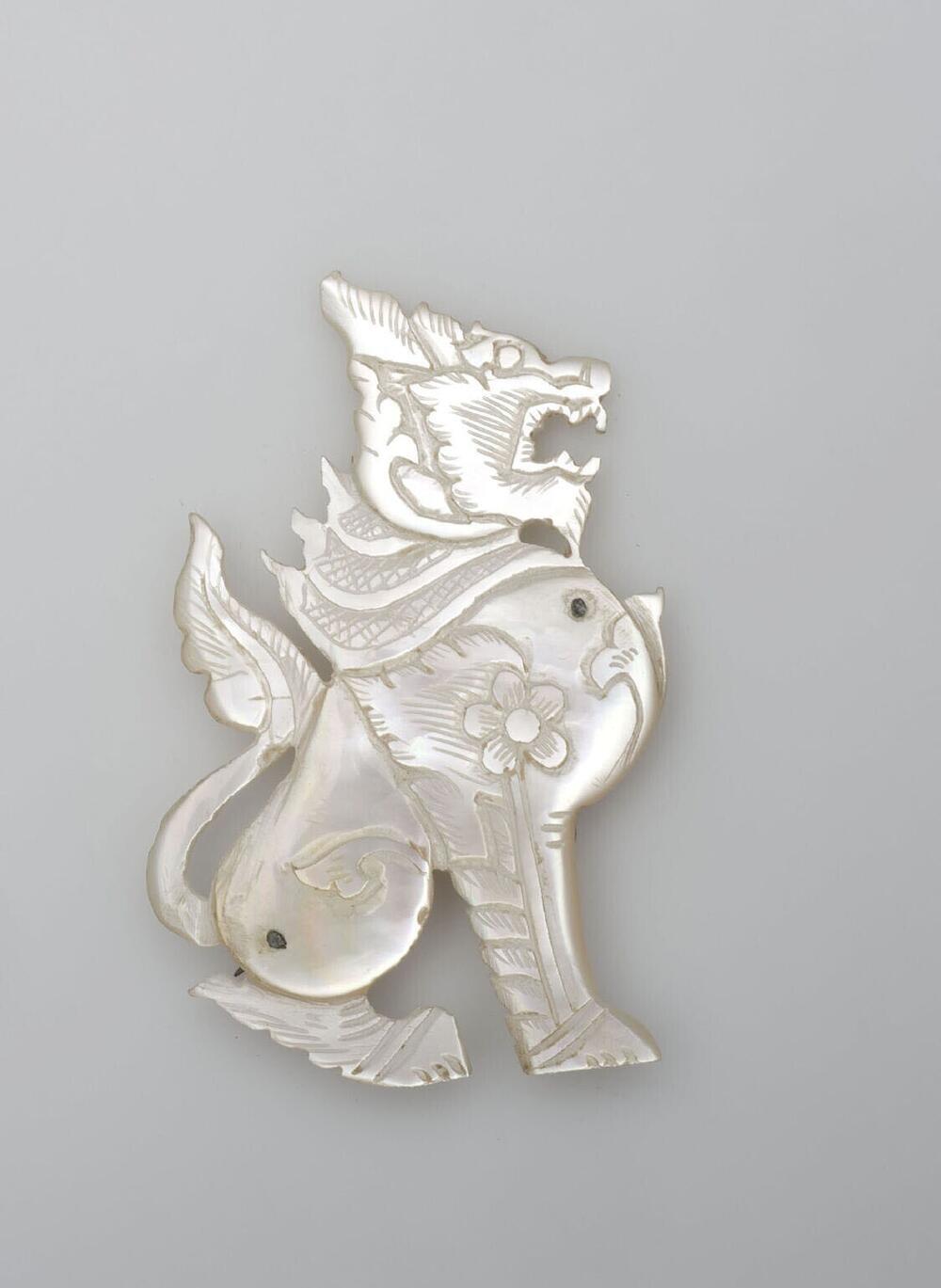 Broche van parelmoer in de vorm van een zittende draak