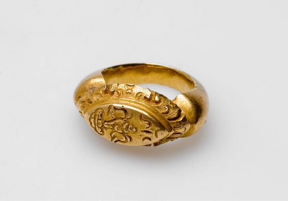 Gouden ring met stempelkussen voorzien van gevleugelde schelp op dubbel lotuskussen