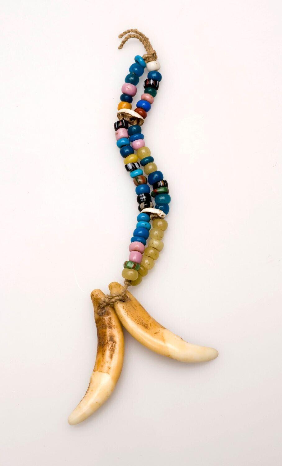 Adornment made of two dog tusks and beadwork