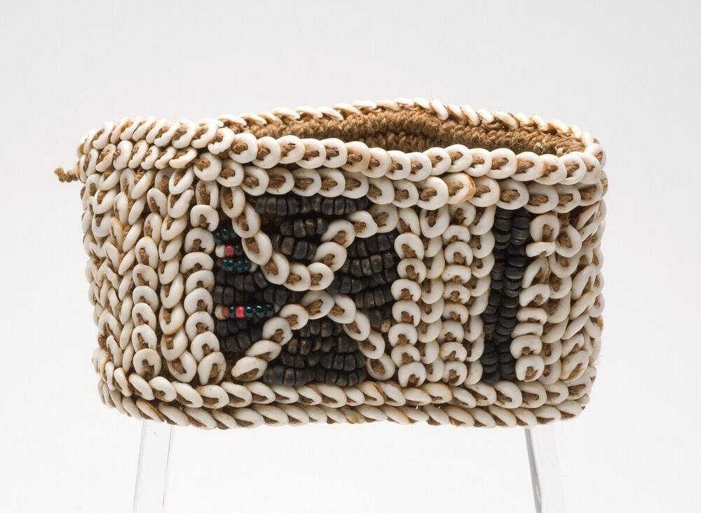 Armband van gevlochten touw met versiering van nassaschelpjes, glaskraaltjes en nootjes
