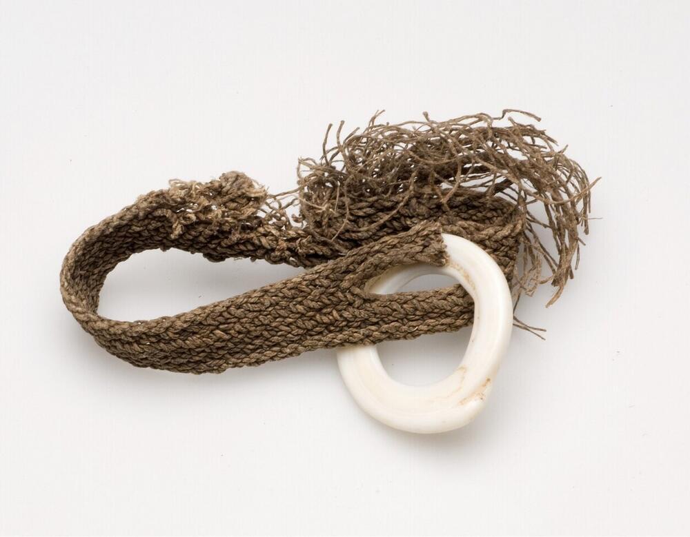 Bracelet of plaited fibres, decorated with a fake shell