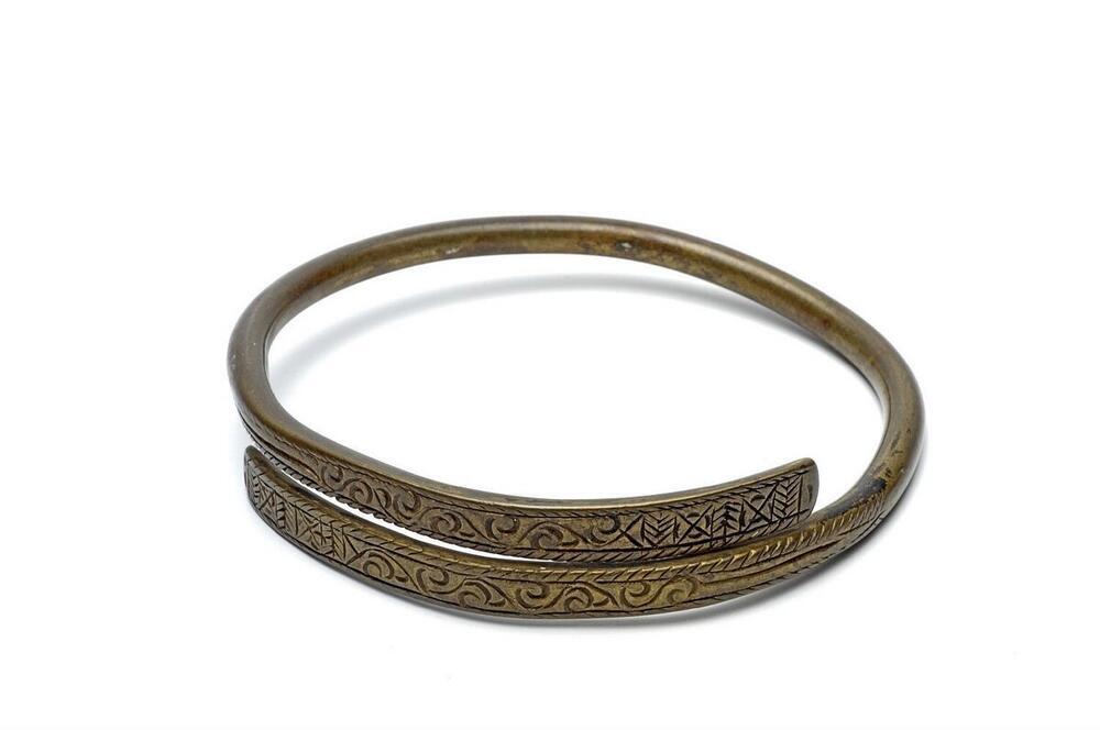Messing armring versierd met ingegrifte figuren