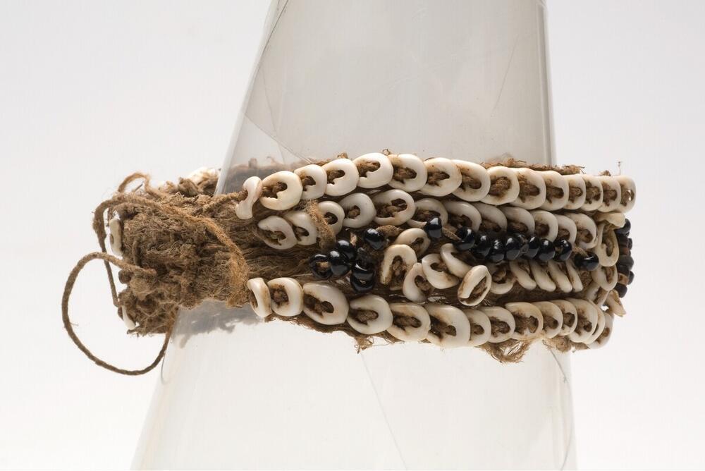 Bovenarmband of polsband van bastreep, zwarte vruchtpitten en schelpen