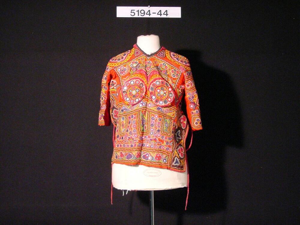 Felrode vrouwenbloes, rijk versierd met spiegeltjes en geborduurde figuren