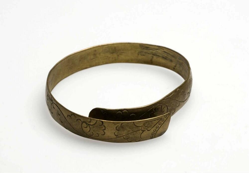 Messingen armband versierd met ciseleerwerk in de vorm van bloem- en bladmotieven, onderdeel van…