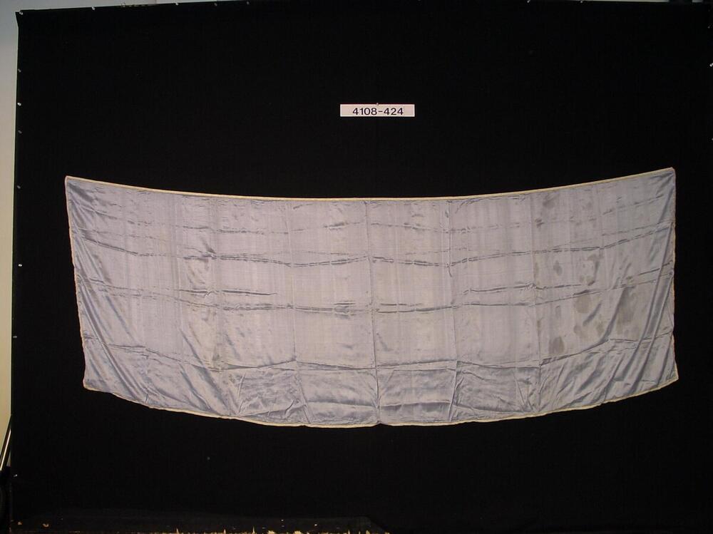 Omslagdoek met aan de rand een zilveren biesje, gedragen op het hoofd of over de schouders