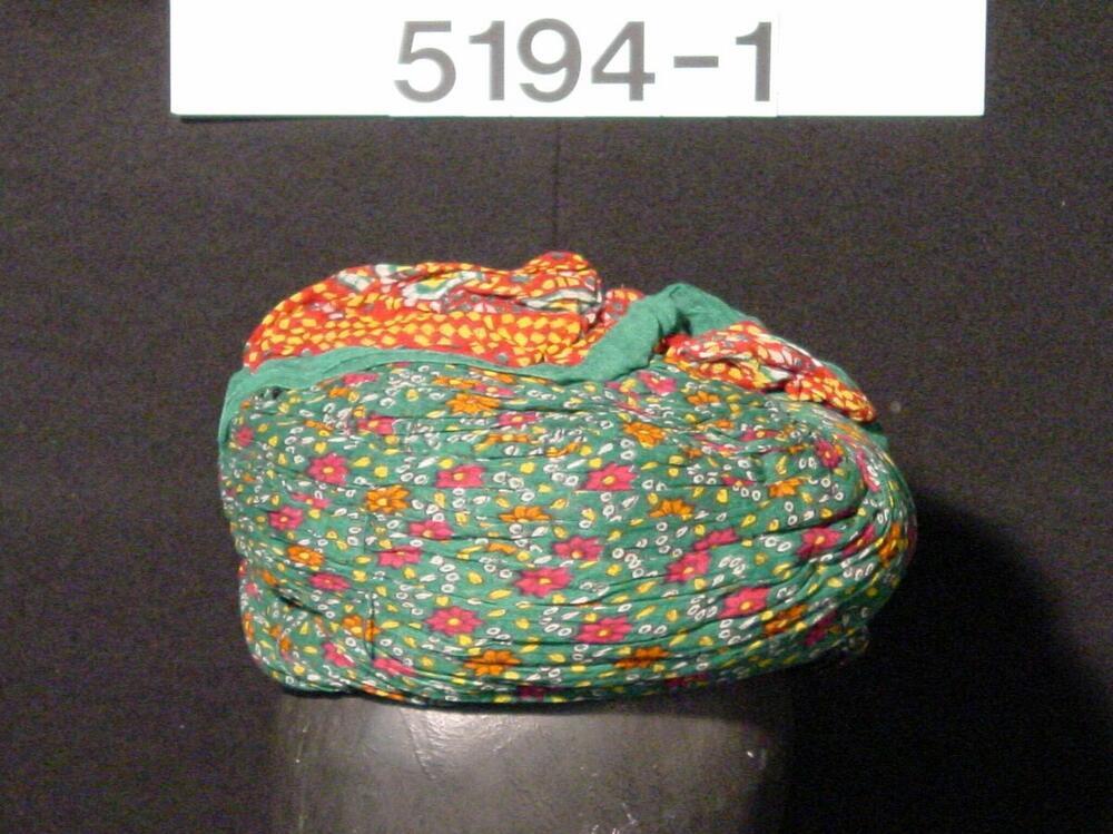 Groene tulband met ornament van paarse en oranje bloempjes met gele blaadjes