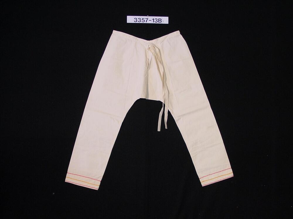 Katoenen broek met borduursel onderaan de pijpen, als onderdeel van een mannenkostuum