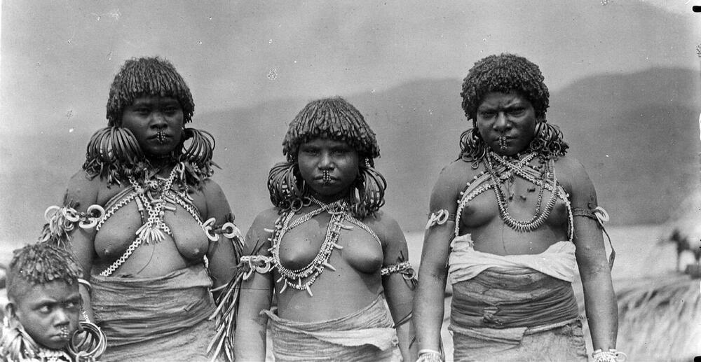 Portrait of three Papuan women (and a child) of the Sentani Lake region with arm, ear, nose, neck…
