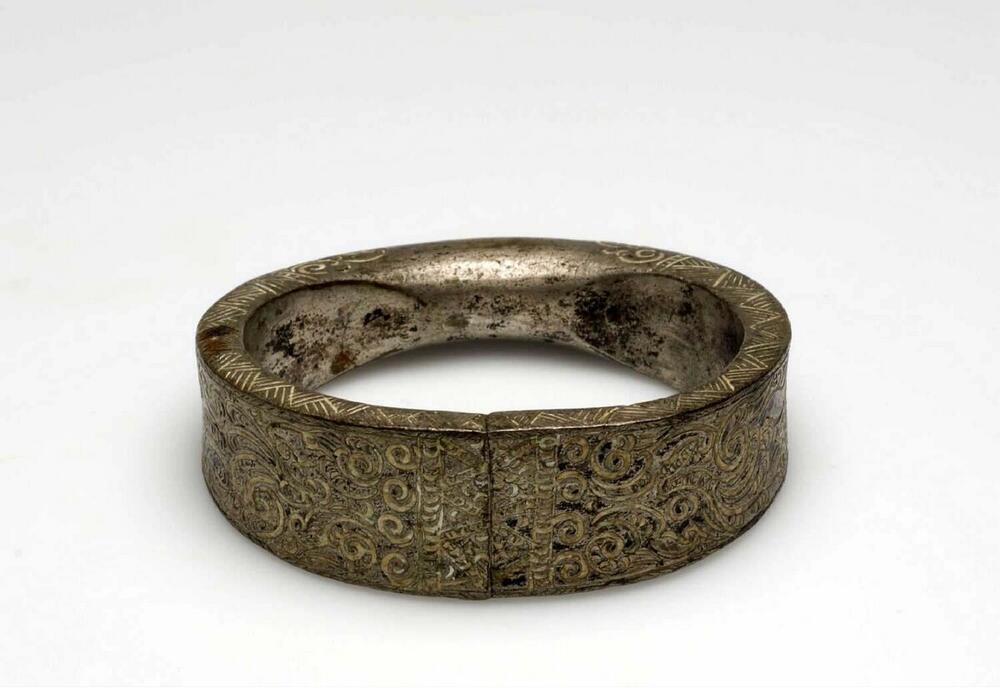 Metalen armband versierd met ciseleerwerk, onderdeel van een paar