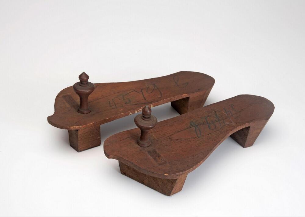 Een paar houten slippers met houten knoppen