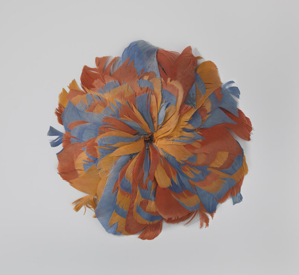 Kokarde van veren in de kleuren oranje en blauw in de vorm van een rozet