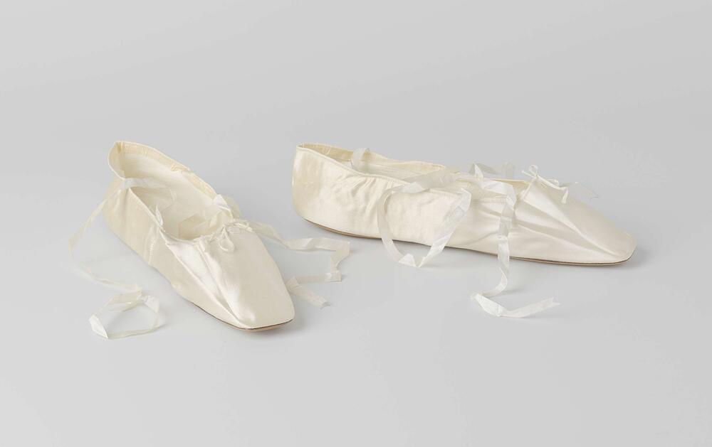 Bruidsschoen plat model met enkelband en dunne witte zijden linten van crème satijn, versierd met…