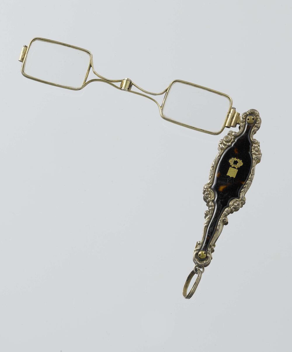 Scharnierlorgnet met montuur van zilver in steel van schildpad omrand met bloemen en rocailles in…