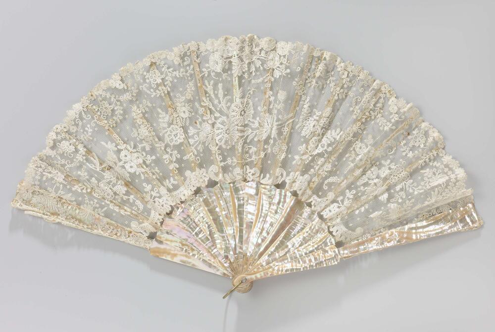 Vouwaaier met blad van wit tule waarop wit kloskant in florale motieven, montuur van parelmoer