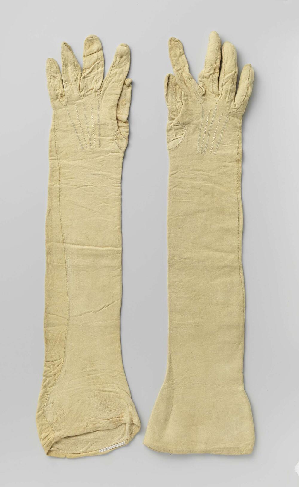 Handschoen van beige zeemleer met op de rug vijf geborduurde uitstralende koorden