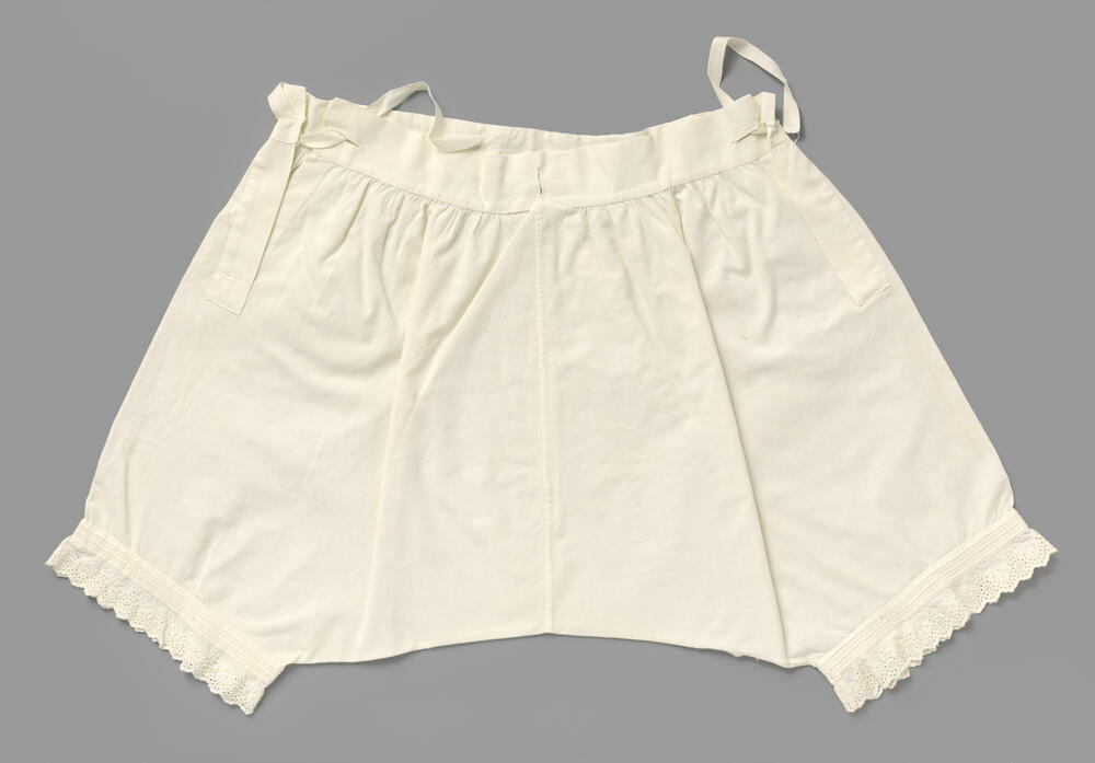 Witte katoenen onderbroek met pijpen, versierd met oprijgen, waartussen gestileerde wit geborduurde…