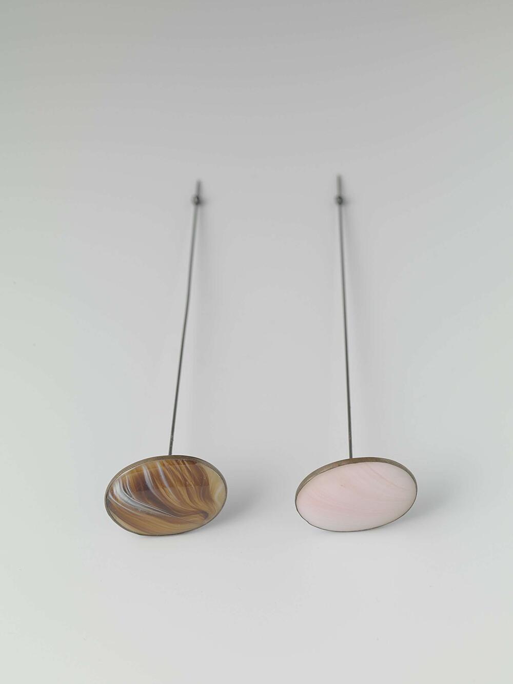Hoedenspeld van metaal met platte, ovale knop waarin gemarmerd bruin/beige/wit glas