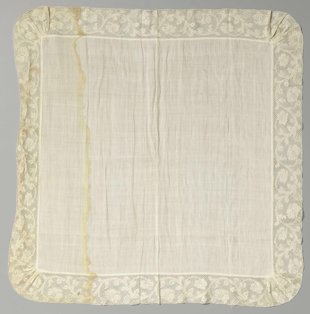 Zakdoek of halsneusdoek van batist en rondom afgewerkt met een strook kloskant met een golvende…