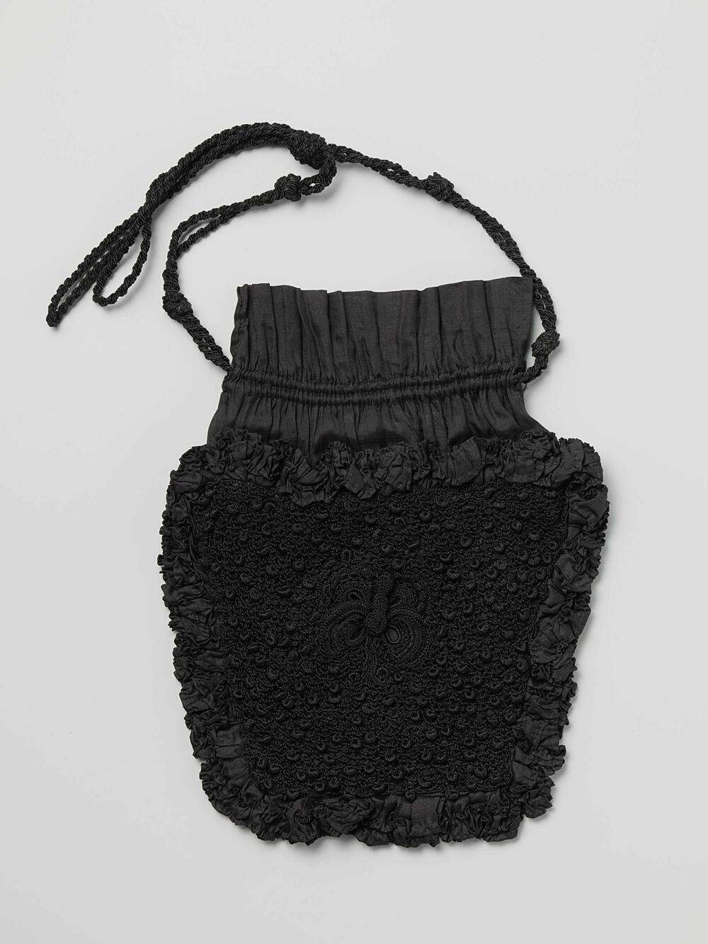 Reticule in trapeziumvormige delen, van zwarte, gehaakte zijde, dat is omboord met zwarte ruches…