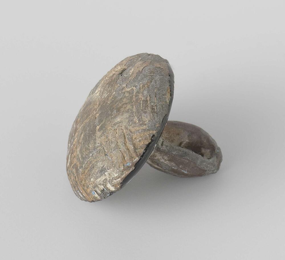 Knoop, rond afgeplat met decoratief patroon
