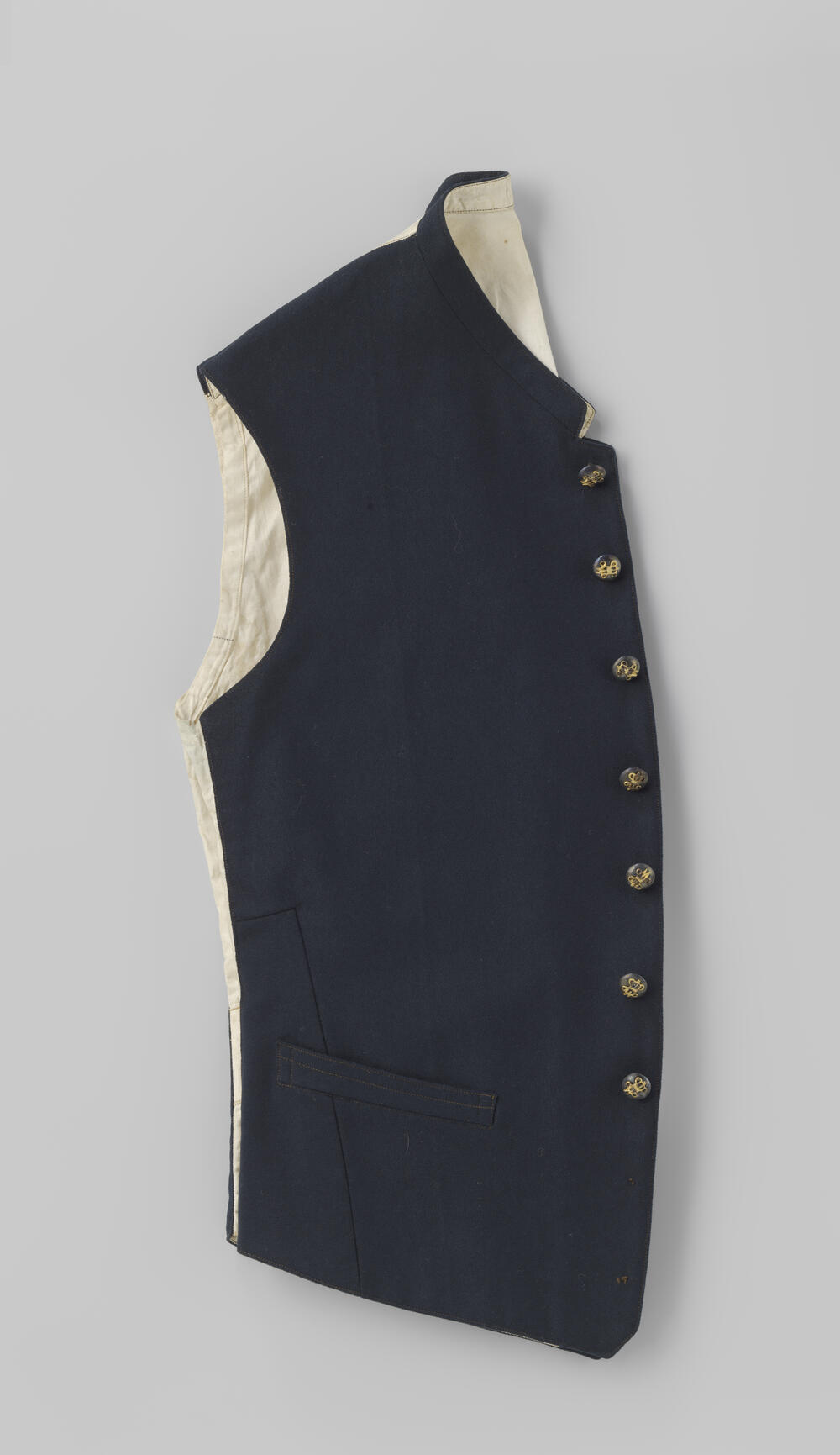 Vest van zwart laken met rug van witte katoen met negen zilveren knopen met gekroonde W