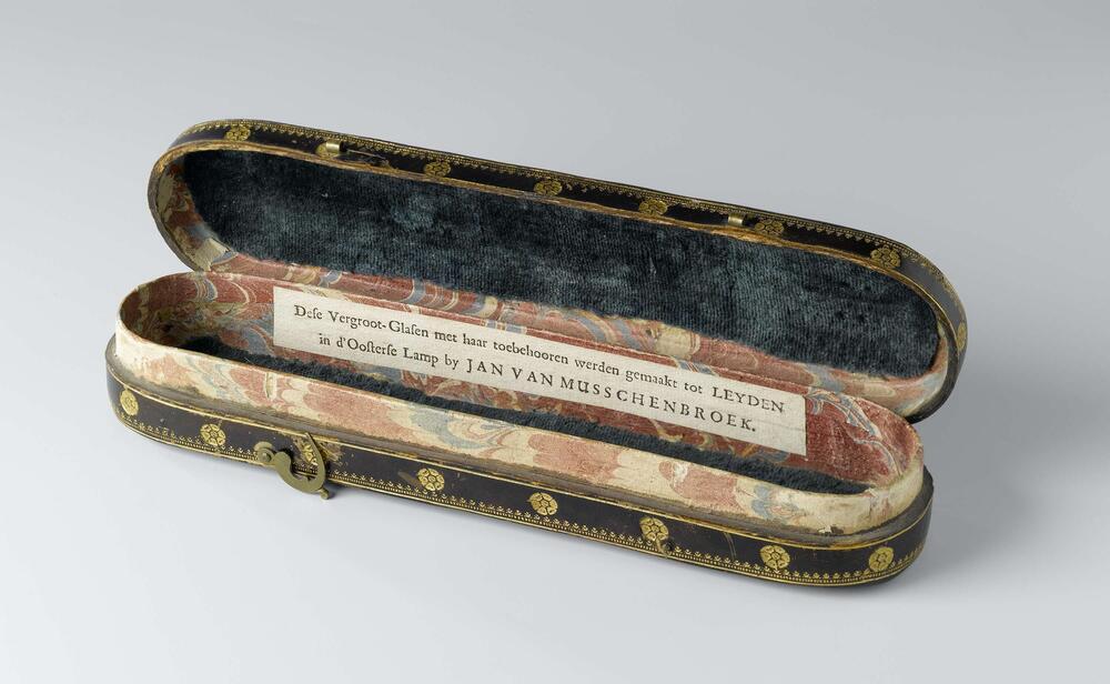 Brillendoos van dik papier met donkerbruin leer bekleed en bedrukt met vergulde florale ornamenten