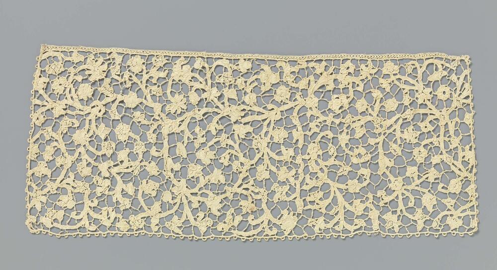 Dasslip van naaldkant met symmetrisch patroon van vele ranken met kleine bladeren en bloemen