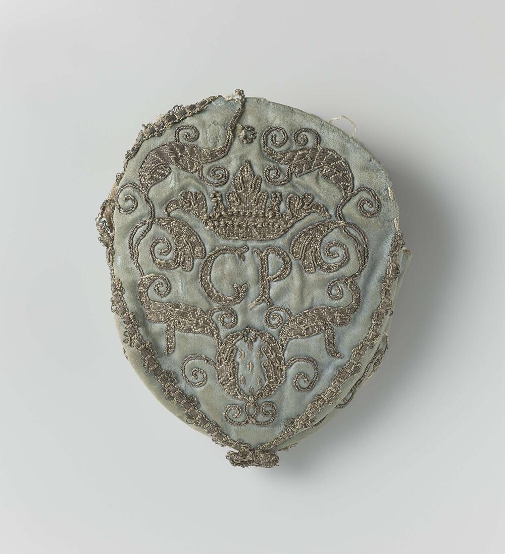 Tas van lichtblauwe zijde, met zilverdraad geborduurd, letters C P waarboven een kroon, omgeven…
