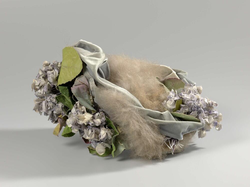 Hoed van velours met konijnenbont en bloemcorsages