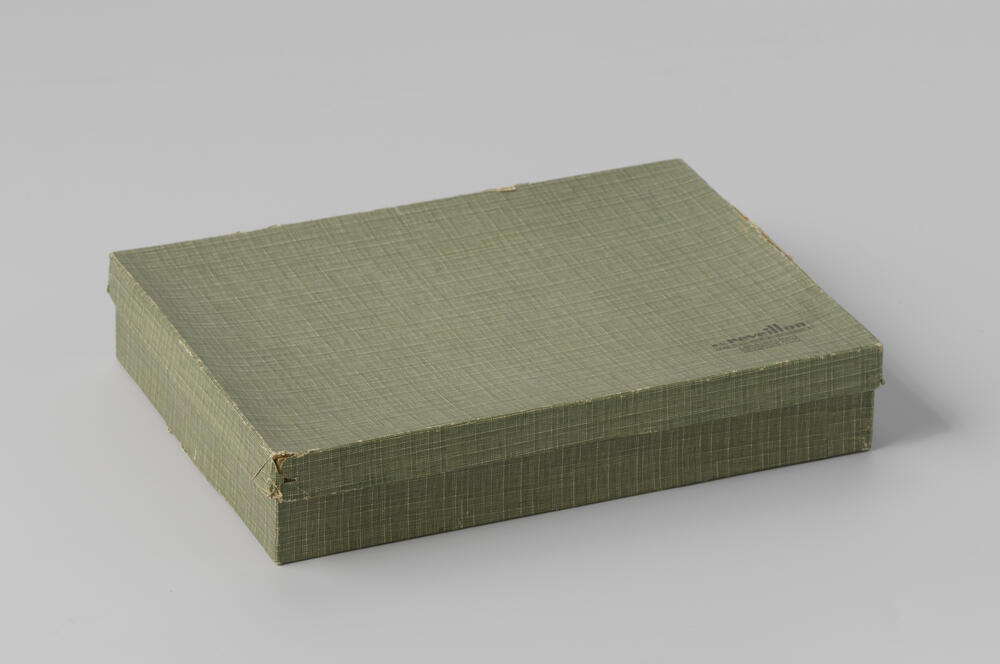 Doos van karton beplakt met groen geruit papier waarop, "n.v. Reveillon/ het huis voor geschenken/…