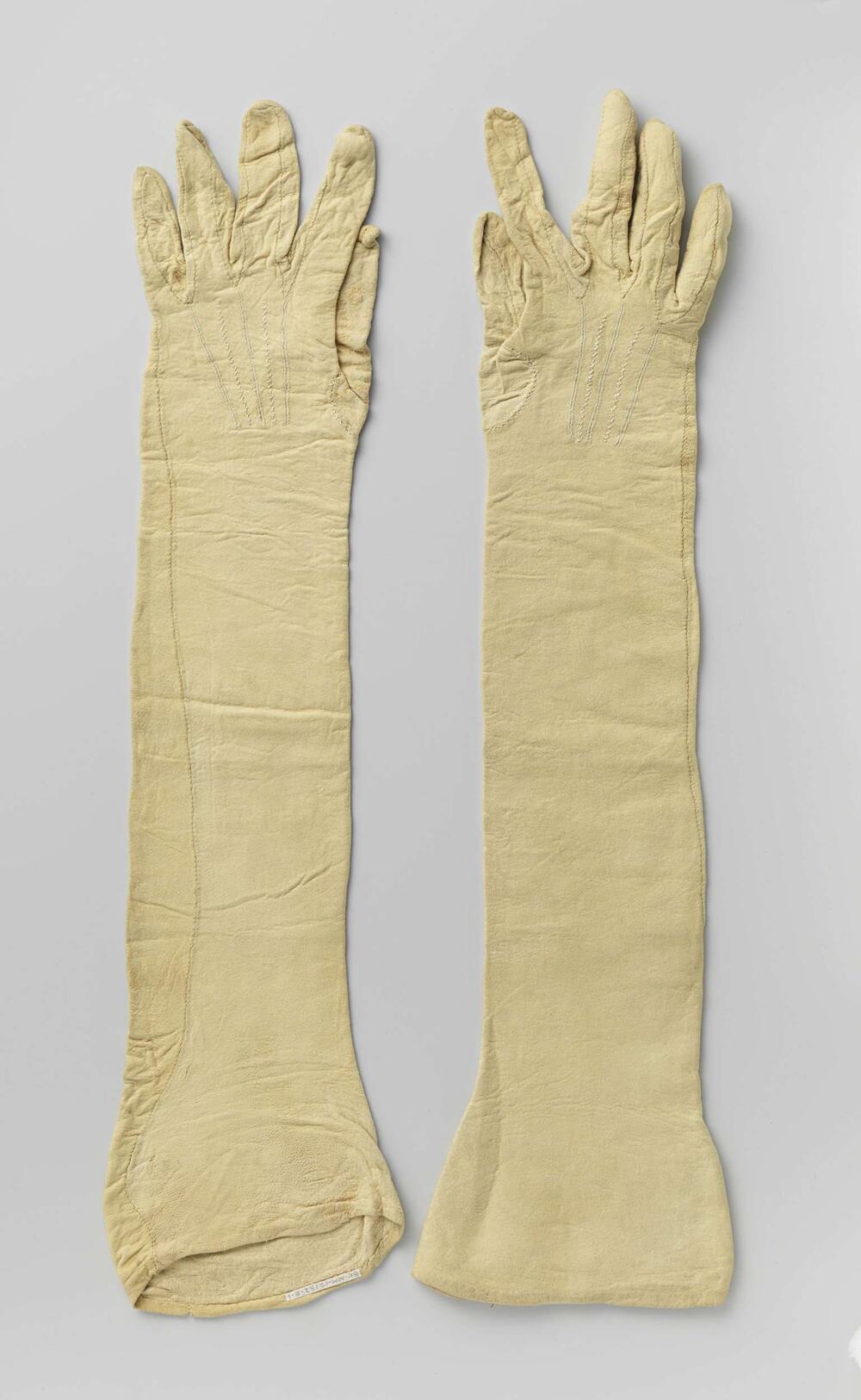 Handschoen van beige zeemleer met op de rug vijf geborduurde uitstralende koorden