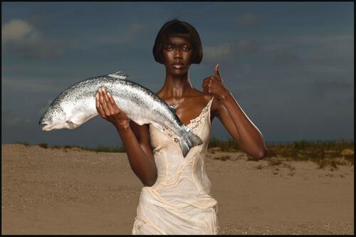 Zwarte vrouw die grote forel vasthoudt