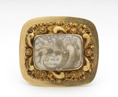 Gouden broche met brede ajourrand en haarwerk