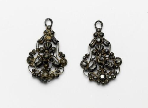 Paar oorbellen met rosetjes en kleine diamantjes, één haak ontbreekt