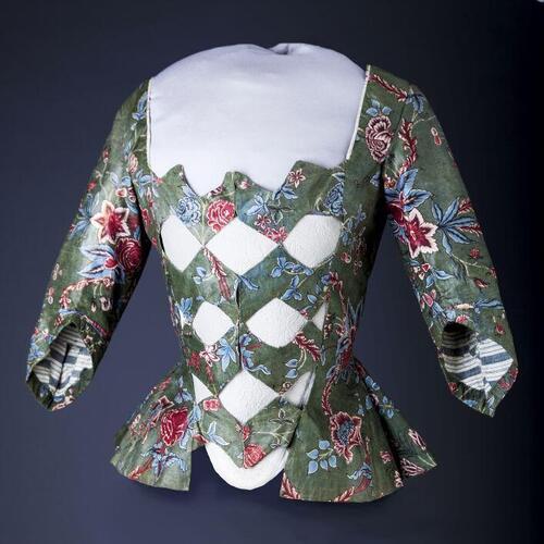 Sitsen vrouwenjak met zigzagvormige vestpandjes, met bloemmotieven op groene grond en blauw-wit…