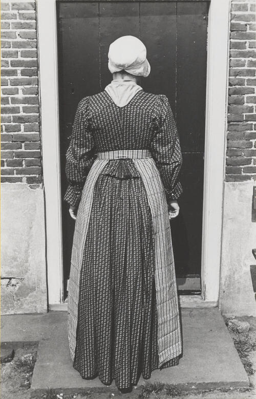 Vrouw verkleed in streekdracht, Huizen, 1945