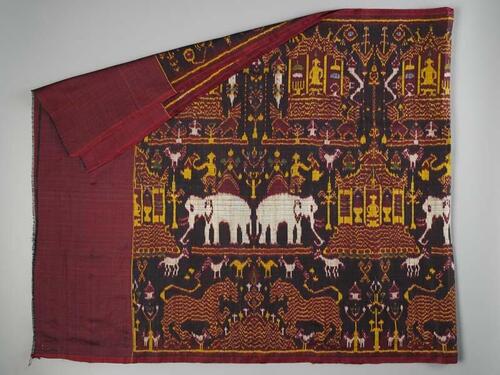 Doek van rode en zwart zijde met ikat inslag tafereel met pagodes, kippen, olifanten, leeuwen  en…