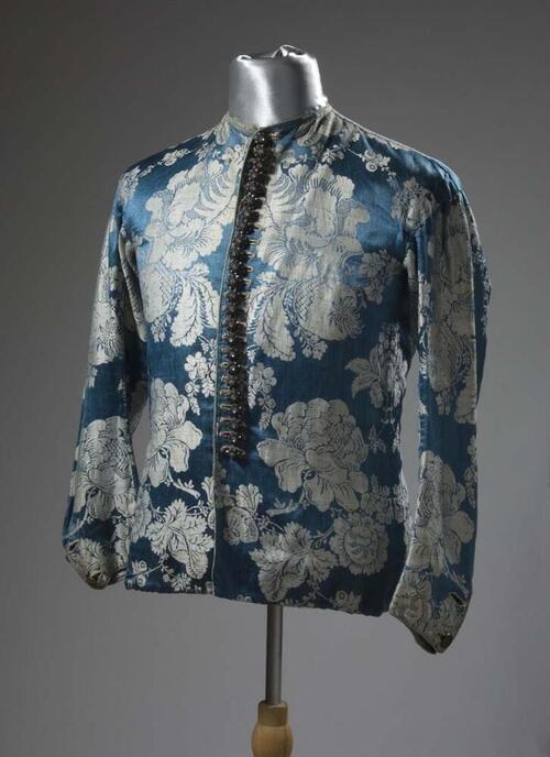 Baeitje of mannenvest van blauwe damast met ingeweven witte bloemen, met aangenaaide zilveren…