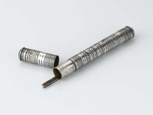 Cylindervormige zilveren naaldenkoker, versierd met rolstempel ornament, hierin 2 naalden