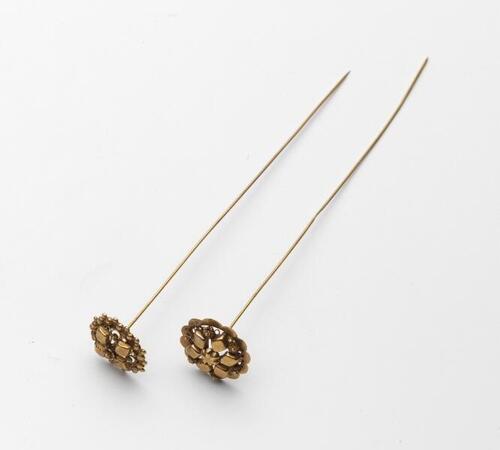 Gouden mutsspeld met rosetje en stampwerk