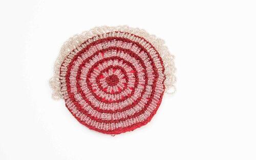 Een rood rond gehaakt katoen tasje, twee toeren gehaakt en dan een toer wit glazen kraaltjes in…
