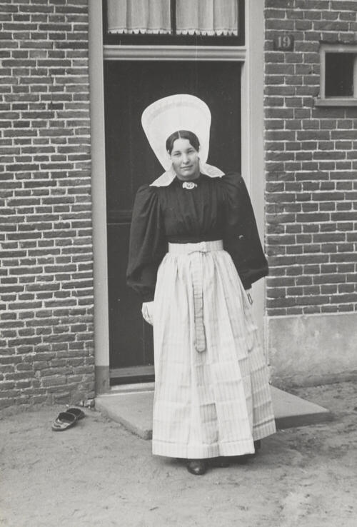 Vrouw verkleed in streekdracht, Huizen, 1945