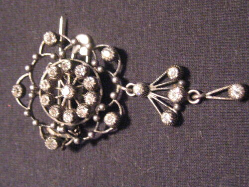 Zilveren broche met bloempendant. Voorzien van draadmotief en imitatie-glasstenen